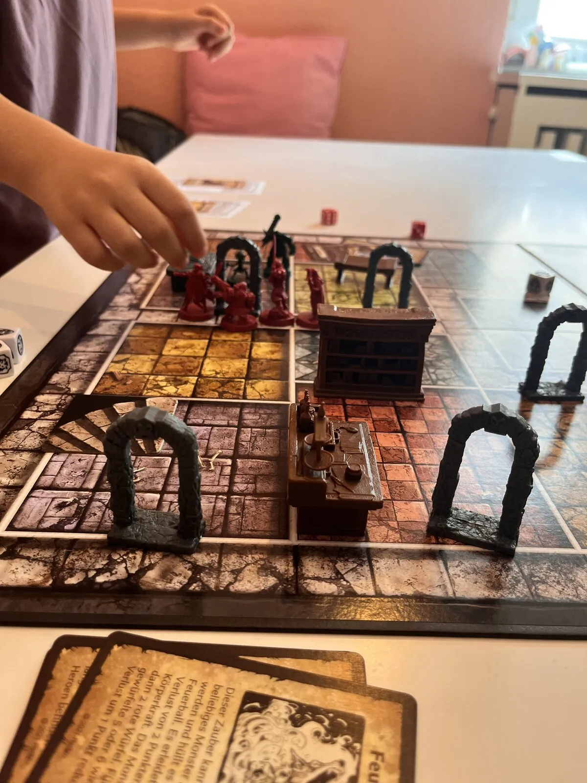 A hand moving a miniature through a HeroQuest dungeon